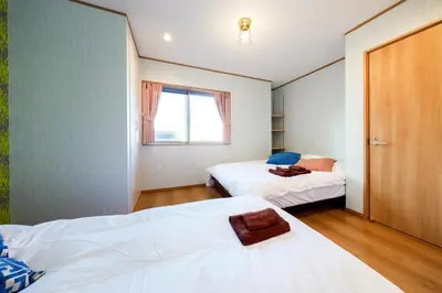 a bedroom with two beds and a window at Domire Setagaya by Tranova in Tokyo