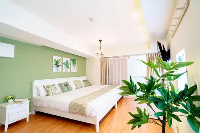 a bedroom with a white bed and a plant at Higashi-Shinjuku 904 in Tokyo