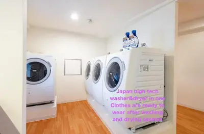 a laundry room with three washing machines and a washer and dryer at Higashi-Shinjuku 904 in Tokyo