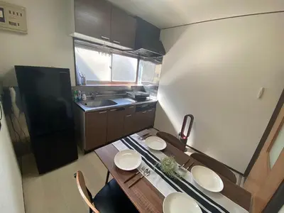 a small kitchen with a wooden table with chairs at Push house Urayasu - Vacation STAY 18038 in Tokyo