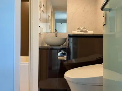 a bathroom with a sink and a toilet and a mirror at COMMA HOUSE Shinjuku 303 in Tokyo