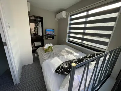 a small bedroom with a bed and a window at COMMA HOUSE Shinjuku 303 in Tokyo