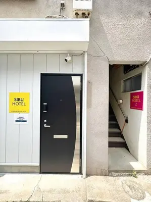 a door to a building with a sun hotel sign on it at \u30a2\u30f3\u30c9\u30b9\u30c6\u30a4\u6e0b\u8c37\u672c\u753a5\u4e01\u76ee1f in Tokyo