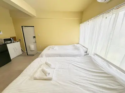 a bedroom with two beds with towels on them at \u30a2\u30f3\u30c9\u30b9\u30c6\u30a4\u6e0b\u8c37\u672c\u753a5\u4e01\u76ee1f in Tokyo
