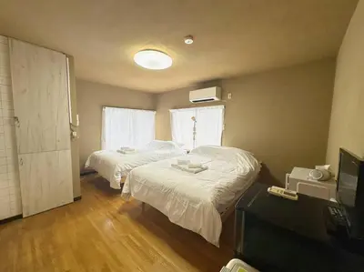 a bedroom with two beds and a television in it at \u30a2\u30f3\u30c9\u30b9\u30c6\u30a4\u6e0b\u8c37\u672c\u753a5\u4e01\u76ee2f in Tokyo