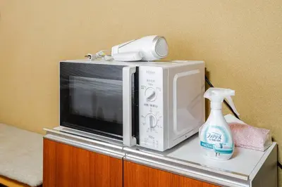 a microwave and a bottle of cleaner on a counter at \u30a2\u30f3\u30c9\u30b9\u30c6\u30a4\u6e0b\u8c37\u672c\u753a5\u4e01\u76ee2f in Tokyo
