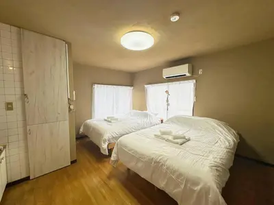 a bedroom with two beds and a window at \u30a2\u30f3\u30c9\u30b9\u30c6\u30a4\u6e0b\u8c37\u672c\u753a5\u4e01\u76ee2f in Tokyo