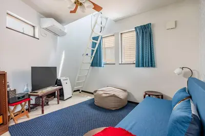 a living room with a blue couch and a ladder at \u30a2\u30f3\u30c9\u30b9\u30c6\u30a4\u6771\u5411\u5cf61\u4e01\u76ee in Tokyo