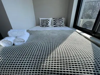 a bed with towels on it in a room with a window at COMMA HOUSE Shinjuku 401 in Tokyo