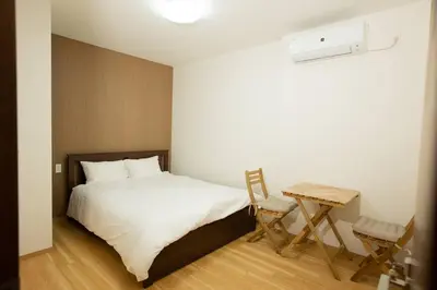 a bedroom with a bed and a table with a chair at \u30a2\u30f3\u30c9\u30b9\u30c6\u30a4\u6d45\u83495\u4e01\u76ee1f in Tokyo