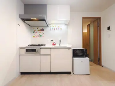 a white kitchen with a sink and a stove at \u65b0\u5bbf\u533a \u65b0\u5bbf\u5fa1\u82d1\u524d\u99c5\u304b\u3089\u6b69\u3044\u30665\u5206 \u30b3\u30f3\u30d3\u30cb1\u5206 \u30a2\u30d1\u30fc\u30c8\u5168\u4f53\u3092\u8cb8\u3057\u51fa\u3059\u6c11\u5bbf in Tokyo