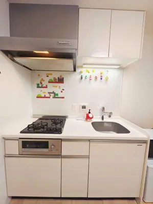 a white kitchen with a sink and a stove at \u65b0\u5bbf\u533a \u65b0\u5bbf\u5fa1\u82d1\u524d\u99c5\u304b\u3089\u6b69\u3044\u30665\u5206 \u30b3\u30f3\u30d3\u30cb1\u5206 \u30a2\u30d1\u30fc\u30c8\u5168\u4f53\u3092\u8cb8\u3057\u51fa\u3059\u6c11\u5bbf in Tokyo