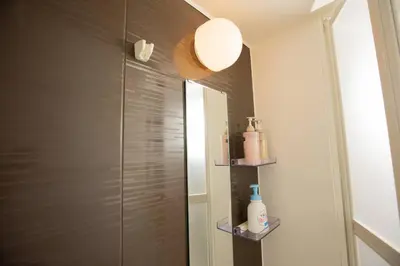 a bathroom with a shower with a mirror at \u30a2\u30f3\u30c9\u30b9\u30c6\u30a4\u6d45\u83495\u4e01\u76ee2f in Tokyo