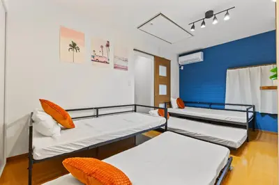 a room with three beds and a blue wall at Tokyo Shinjuku Group Stay-Up to 16 Guests ISJ36 in Tokyo