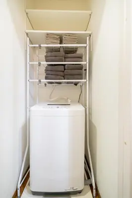 a small refrigerator in a laundry room with towels at Tokyo Shinjuku Group Stay-Up to 16 Guests ISJ36 in Tokyo