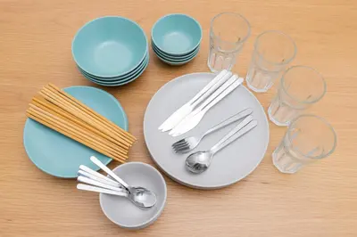 a table with plates and forks and spoons and glasses at Kosumosu in Tokyo