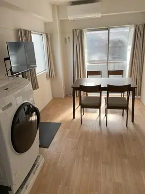 a living room with a table and chairs and a tv at G&R House301 in Tokyo