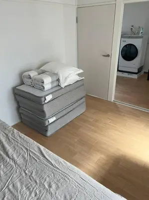 a bedroom with a bed with pillows and a mirror at G&R House301 in Tokyo
