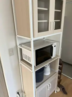 a white cabinet with a microwave on a shelf at G&R House301 in Tokyo