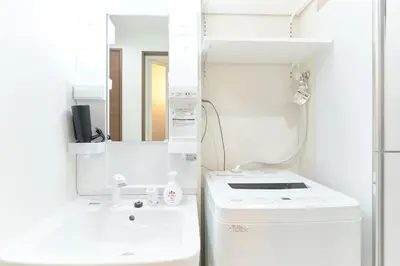 a white bathroom with a sink and a mirror at GRANQUAL Horikiri by Tranova in Tokyo