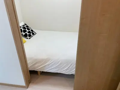 a small bed with a black and white pillow on it at COMMA HOUSE Kitaikebukuro 303 in Tokyo