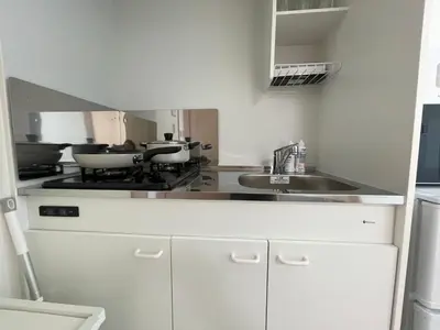 a kitchen with a stove and a sink at COMMA HOUSE Kitaikebukuro 303 in Tokyo