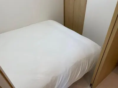 a bed in a room with a white bedsheet at COMMA HOUSE Kitaikebukuro 303 in Tokyo