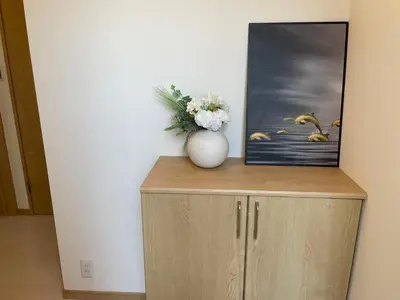 a vase with flowers on top of a cabinet at COMMA HOUSE Kitaikebukuro 303 in Tokyo