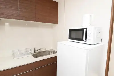 a microwave on top of a refrigerator in a kitchen at \u548c\u30ce\u6953cottage\u7b2c\u4e09 \u65b0\u5bbf\u306e2\u968e\u5efa\u30664\u5ba42\u30b7\u30e3\u30ef\u30fc2\u30c8\u30a4\u30ec in Tokyo