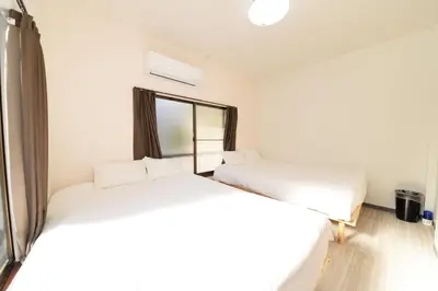 two beds in a room with a window at \u548c\u30ce\u6953cottage\u7b2c\u4e09 \u65b0\u5bbf\u306e2\u968e\u5efa\u30664\u5ba42\u30b7\u30e3\u30ef\u30fc2\u30c8\u30a4\u30ec in Tokyo