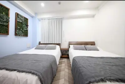 two beds in a room with blue walls at Shibuya WAVE401 SW41 in Tokyo