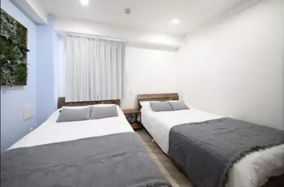 two beds in a room with blue walls at Shibuya WAVE401 SW41 in Tokyo