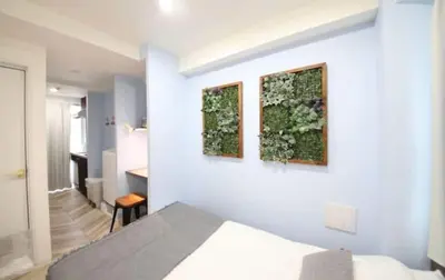 a bedroom with a bed and two paintings on the wall at Shibuya WAVE401 SW41 in Tokyo