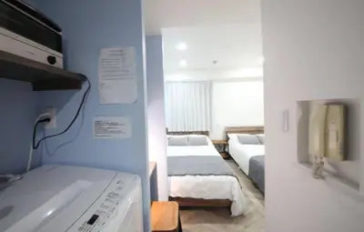 two views of a room with two beds and a tv at Shibuya WAVE401 SW41 in Tokyo