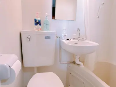 a white bathroom with a toilet and a sink at 406, Shinjuku City, JR Yamanote Line, 6 min walk to stn in Tokyo