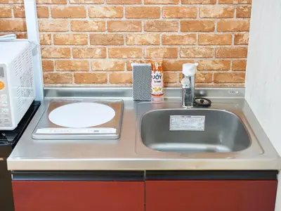 a kitchen counter with a sink and a microwave at Shimbashi Hotel Sho in Tokyo