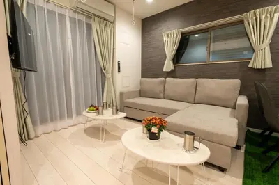 a living room with a couch and two tables at \u30ed\u30fc\u30ba\u30d1\u30fc\u30af\u516b\u756a\u9928 in Tokyo