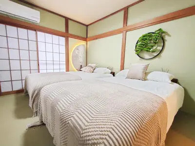 two beds sitting in a room with windows at \u522b\u5885A\u68df \u6c60\u888b\u5546\u5708 \u5927\u585a\u7ad97\u5206\u949f 3\u4e2a\u623f\u95f4 \u4ea4\u901a\u4fbf\u5229 \u6700\u59278\u4eba Ikebukuro center 7 mins to ST Max 8P \u76f4\u8fbe\u65b0\u5bbf \u6d89\u8c37 \u8868\u53c2\u9053 \u6c60\u888b \u4e0a\u91ce \u4ee3\u4ee3\u6728 \u94f6\u5ea7 \u539f\u5bbf in Tokyo