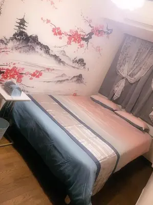 a bed in a room with a painting on the wall at BandK Kouenji in Tokyo