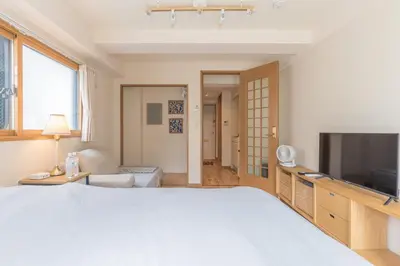 a bedroom with a large bed and a television at Ken Hotel Tokyo Shinjuku in Tokyo