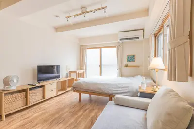 a bedroom with a bed and a tv and a couch at Ken Hotel Tokyo Shinjuku in Tokyo