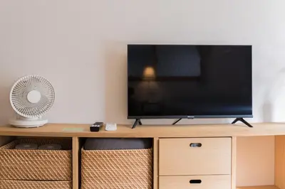 a flat screen tv sitting on top of a wooden cabinet at Ken Hotel Tokyo Shinjuku in Tokyo