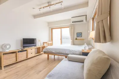 a bedroom with a bed and a tv and a couch at Ken Hotel Tokyo Shinjuku in Tokyo