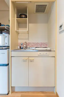 a kitchen with white cabinets and a sink at Ken Hotel Tokyo Shinjuku in Tokyo