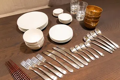 a table with white plates and silver forks and knives at Vistalia in Tokyo