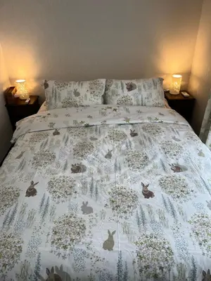a bed with a blanket with cats on it at \u5c0f\u6e13\u8358 in Tokyo