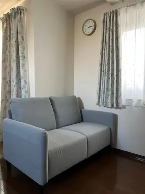a couch in a living room with a clock on the wall at \u5c0f\u6e13\u8358 in Tokyo