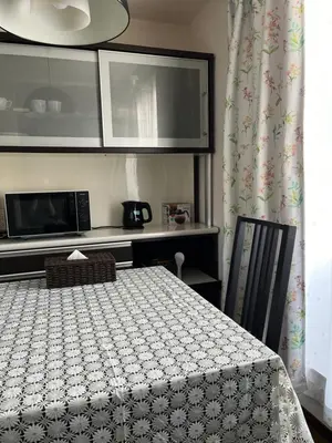 a room with a table and a microwave and a kitchen at \u5c0f\u6e13\u8358 in Tokyo