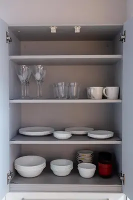 a pantry filled with white dishes and wine glasses at NIYS apartments 82type in Tokyo