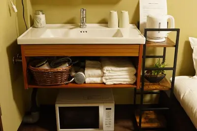 a bathroom sink and a microwave under a sink at Remon House Asakusa Tokyo in Tokyo